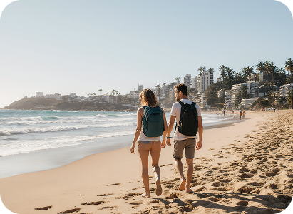 Aerial view of Bondi Beach's golden sands and turquoise waves with surfers